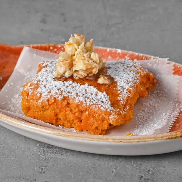 A Chick N Jones sweet potato pie bar, topped with powdered sugar and candied pecans.